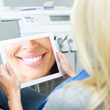 woman looking at smile on tablet