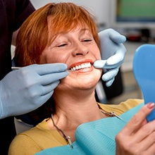 dentist showing woman smile in mirror